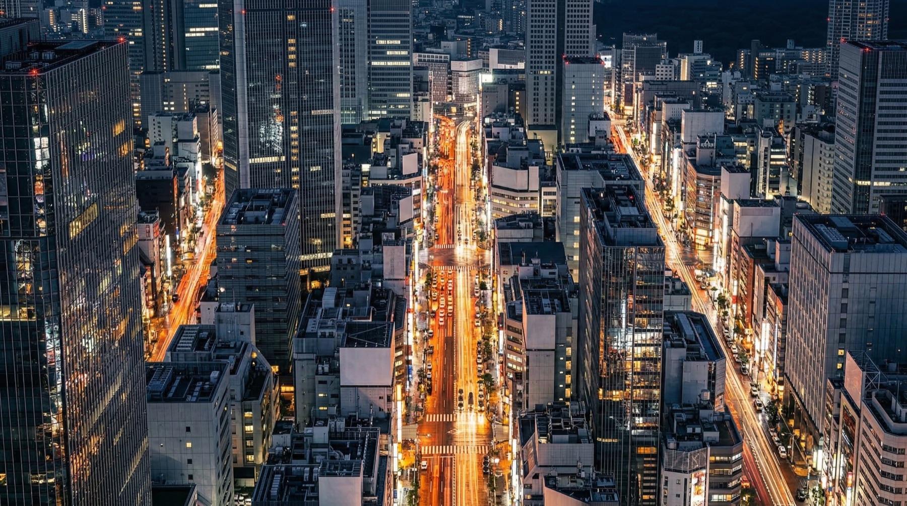 Tokyo aerial night — amber rivers of light through silver city